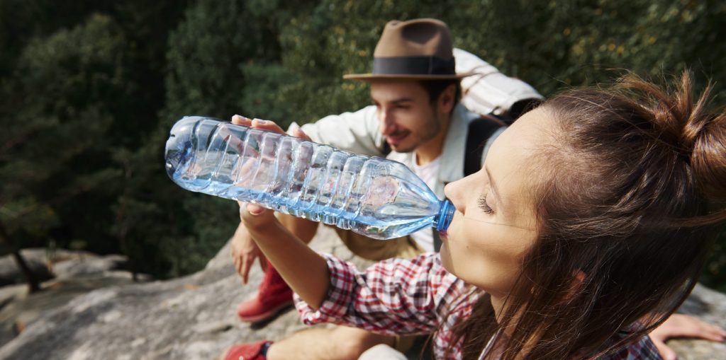 Female hiker drinking water in the mountains